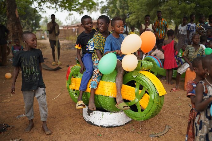 Enfants togolais s'amusant sur une fausse moto
